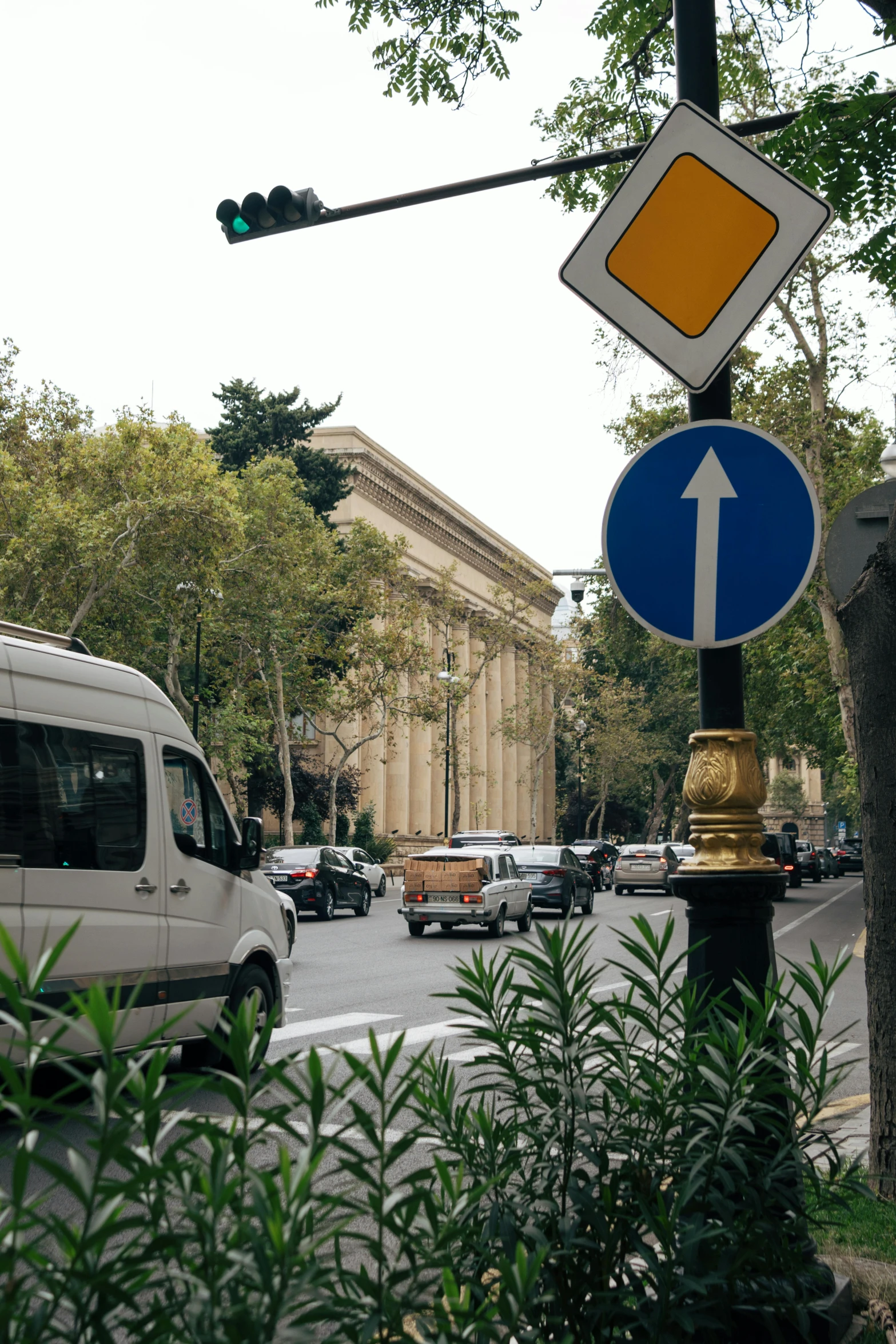 a white van and a blue yellow and white sign and trees