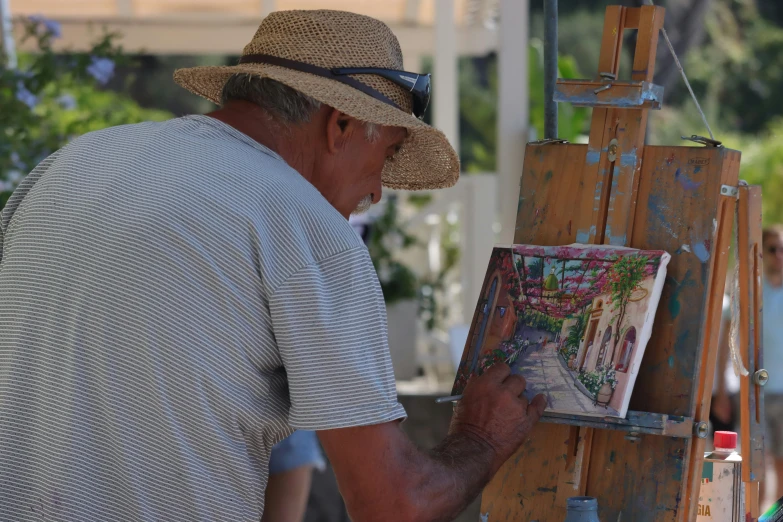 an older man painting a scene in a tropical style