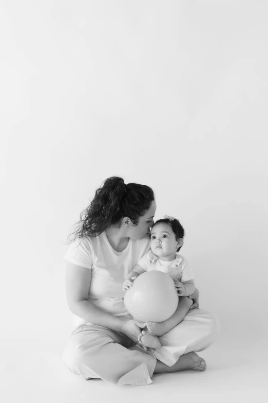 a young woman holding up a white ball and holding it