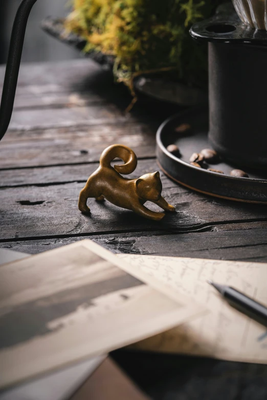 a toy cat sitting on a wooden surface