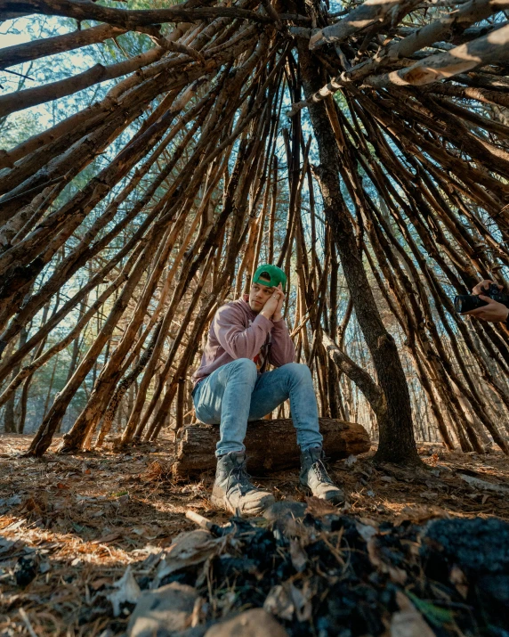 a man with a green hat sitting under a tree