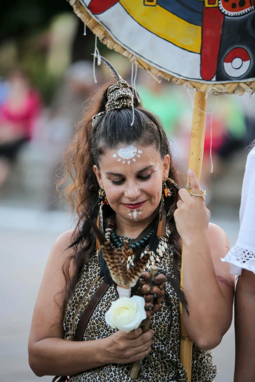 a woman dressed in a native dress holding an umbrella