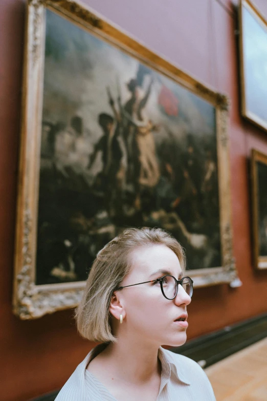 a lady wearing glasses looking to one side of the wall