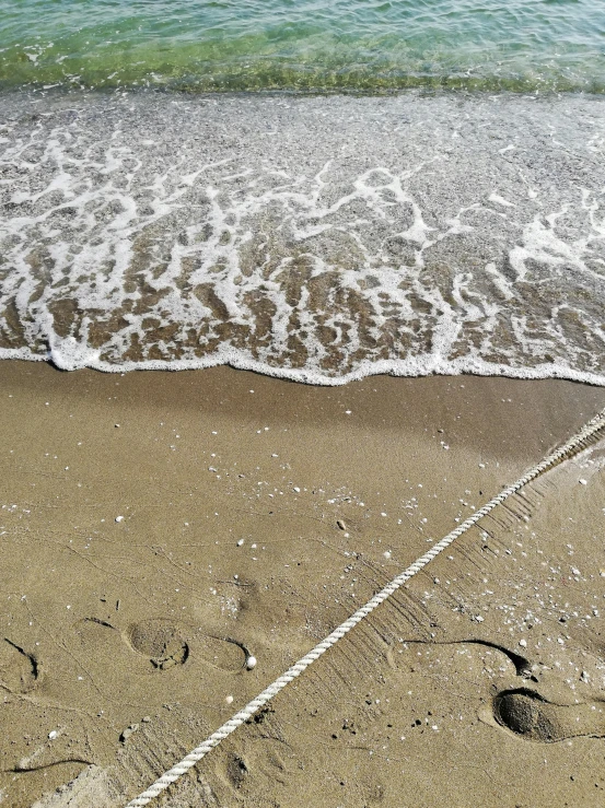 a heart in the sand near the beach and a wave