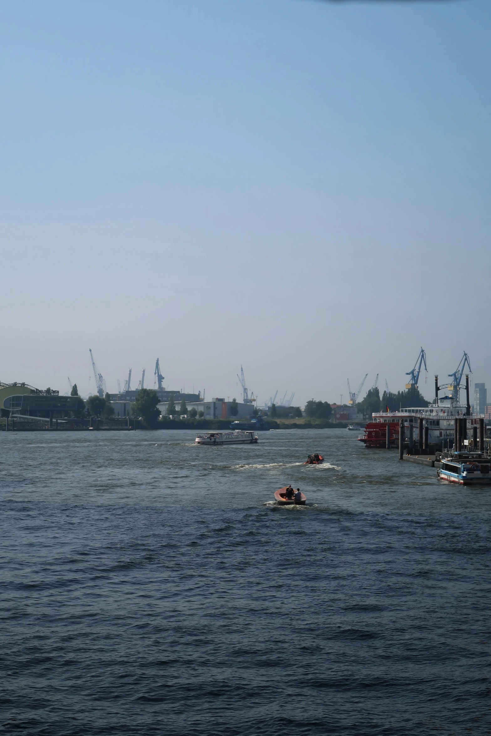 boats on the water with cranes in background