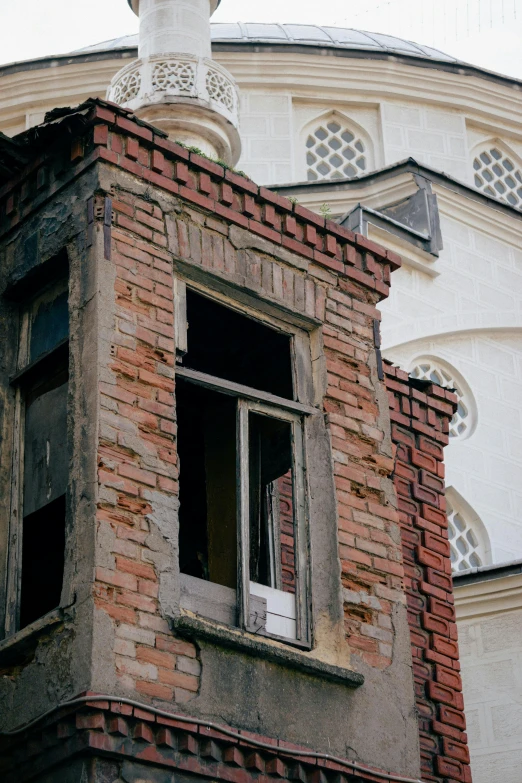 a red brick building with two windows and a white roof