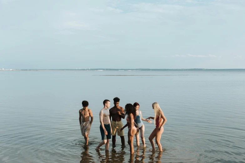 a group of people standing on the edge of a lake