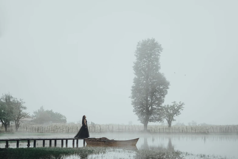 a lone boat is on the lake in a foggy day