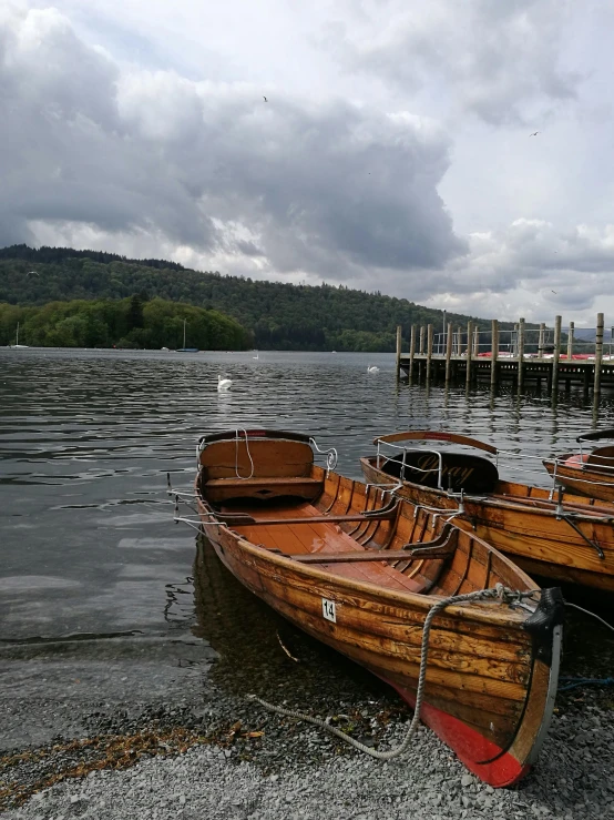 three boats in the water on the shore