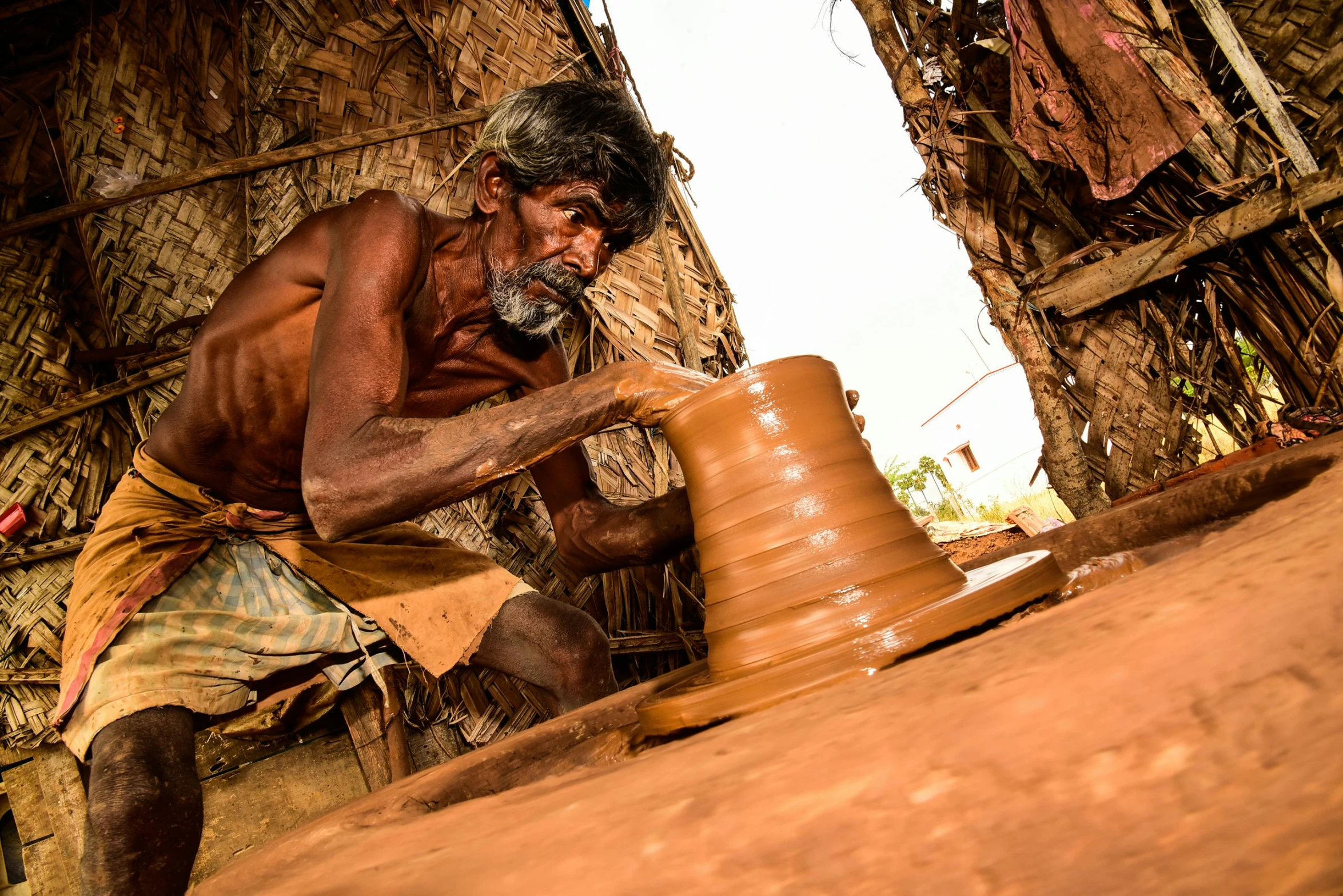 the man is making the pots on the pottery wheel