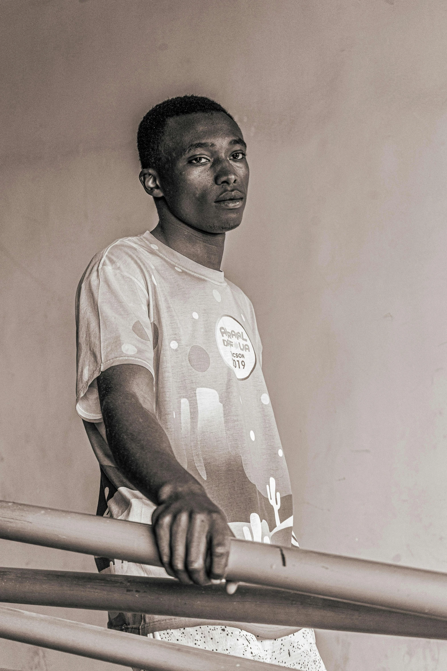 a young man holding onto a metal fence