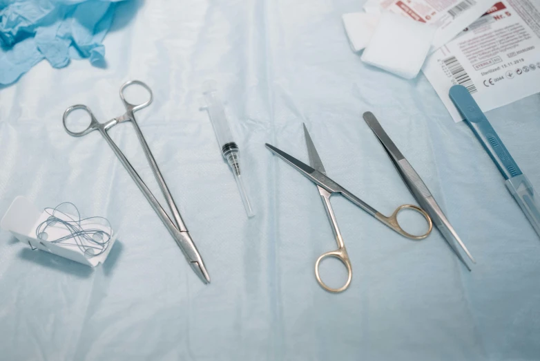 an arrangement of surgical instruments are laid out on a bed