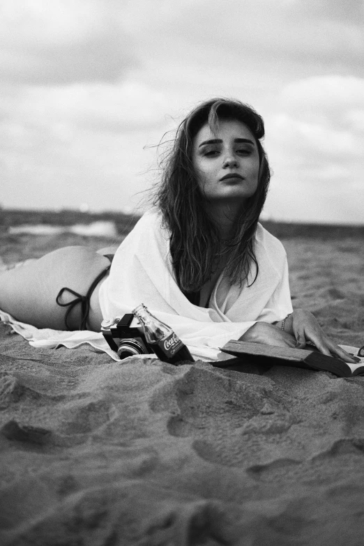 a woman laying on her back in the sand