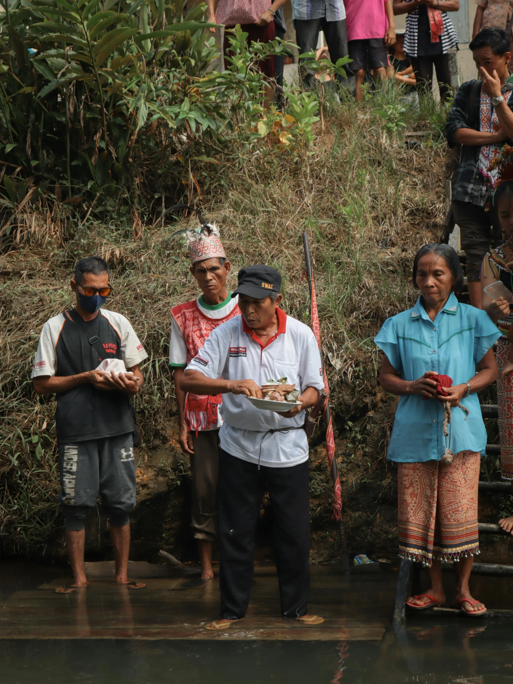 people waiting at a watering hole for a few fish