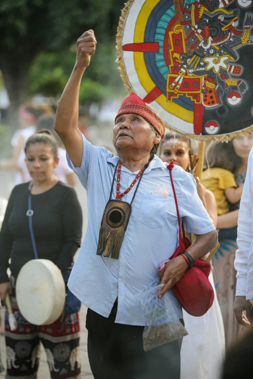 an old woman holding a large white fan