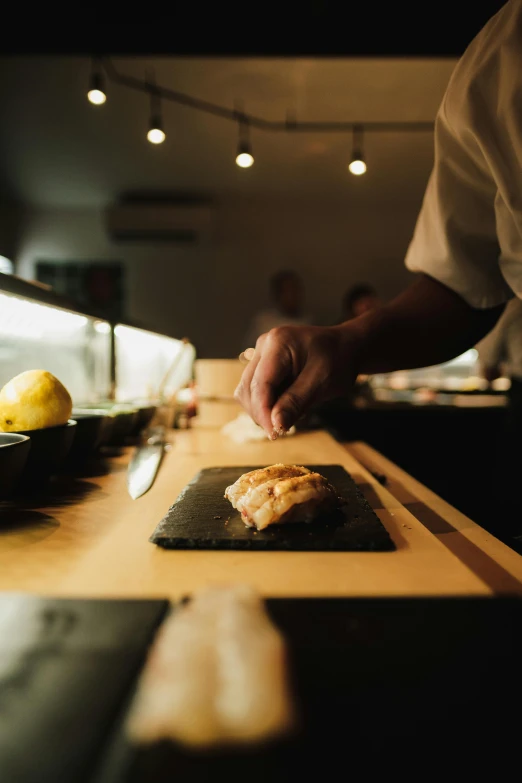 a person making food on a black plate