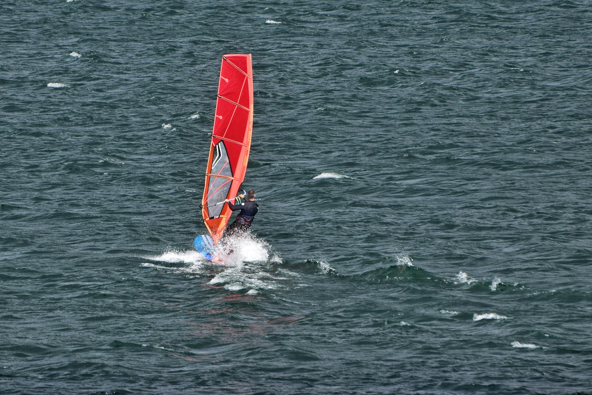 a man riding a windsurfer on top of a body of water