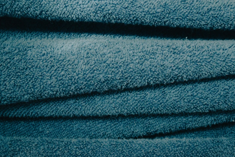 green and blue towel folded up in rows