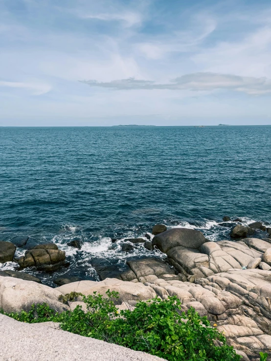 a large body of water next to some rocky rocks