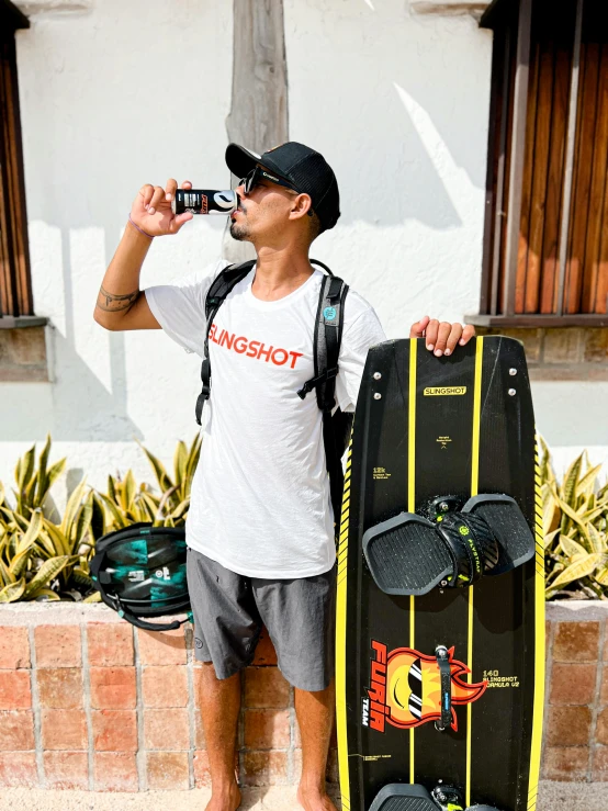 a person is drinking from a water bottle next to a skateboard