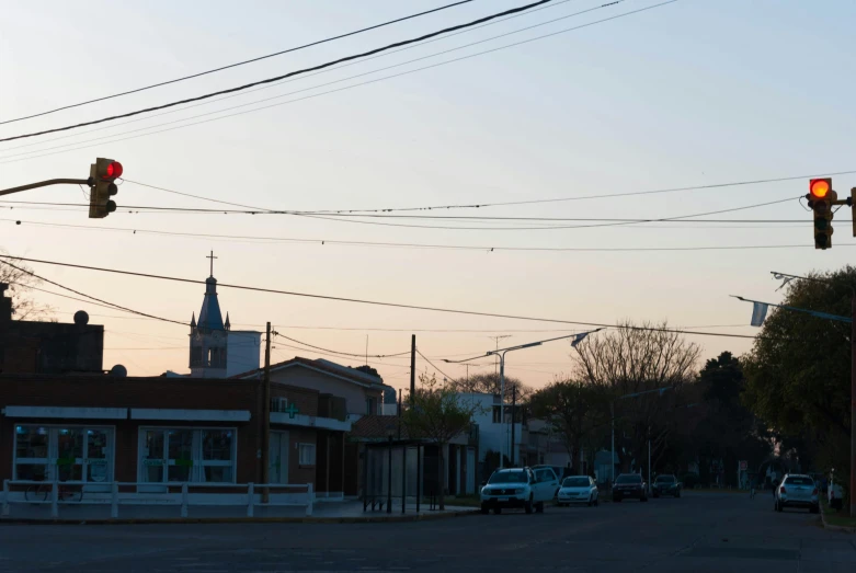 a red stoplight is hanging over an empty road