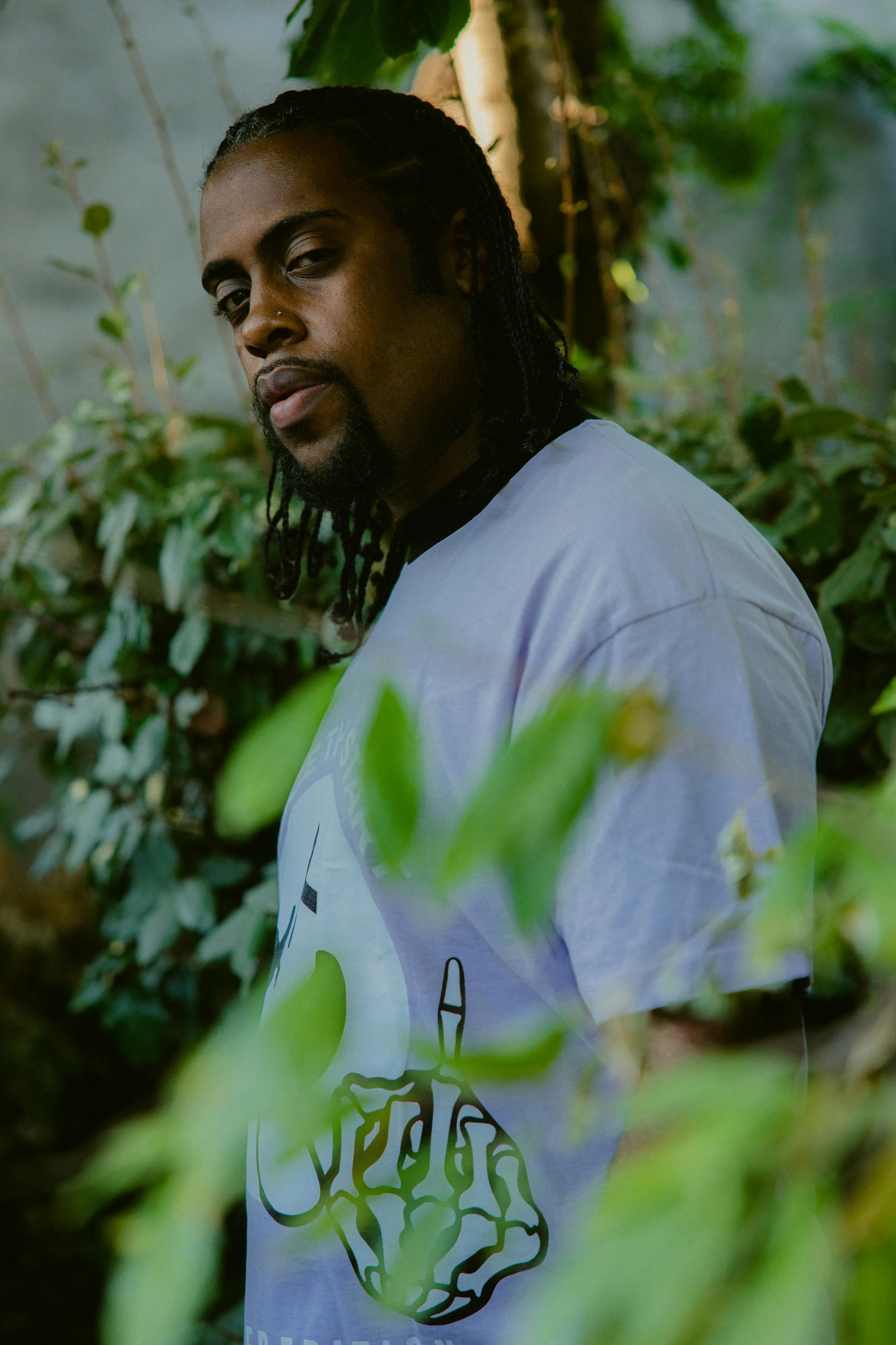 a man is standing near plants while looking away