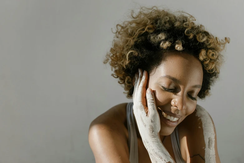 a woman smiling while wearing gloves in front of her