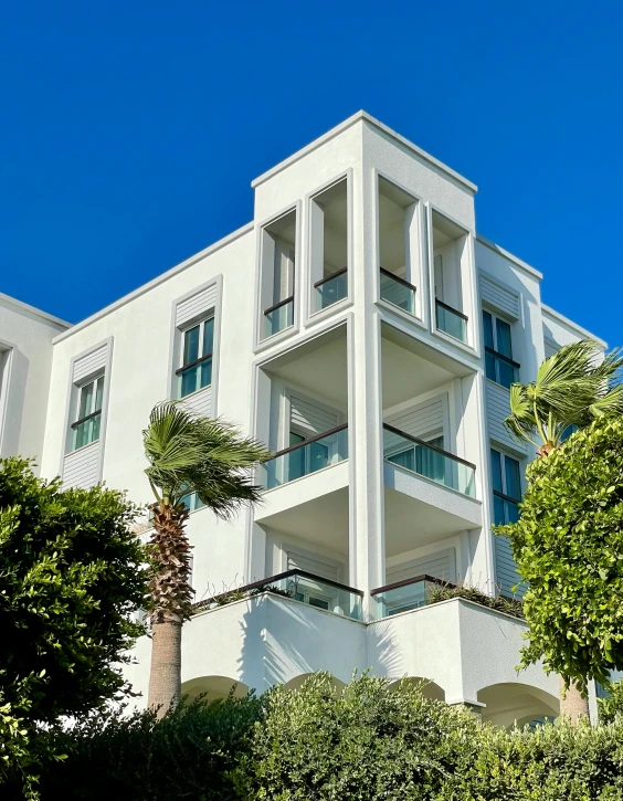 this white apartment building has several balconies on top