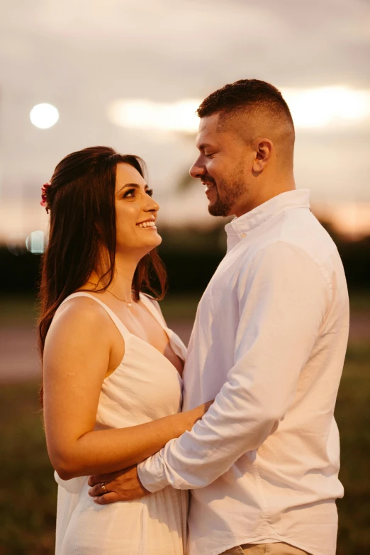 a couple is standing close together during sunset