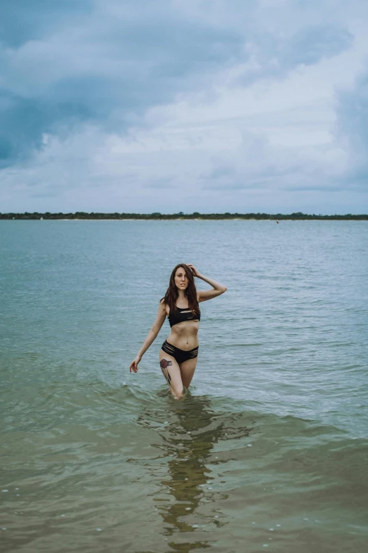 a girl in a bikini walks out of the water