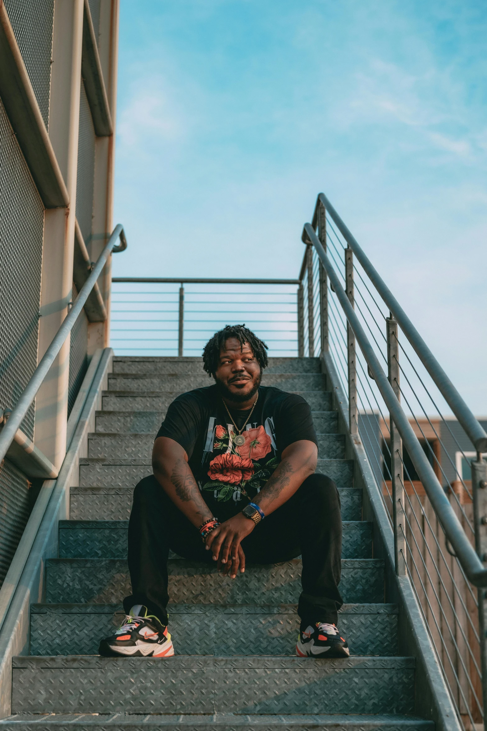 a man sits on stairs in front of a building