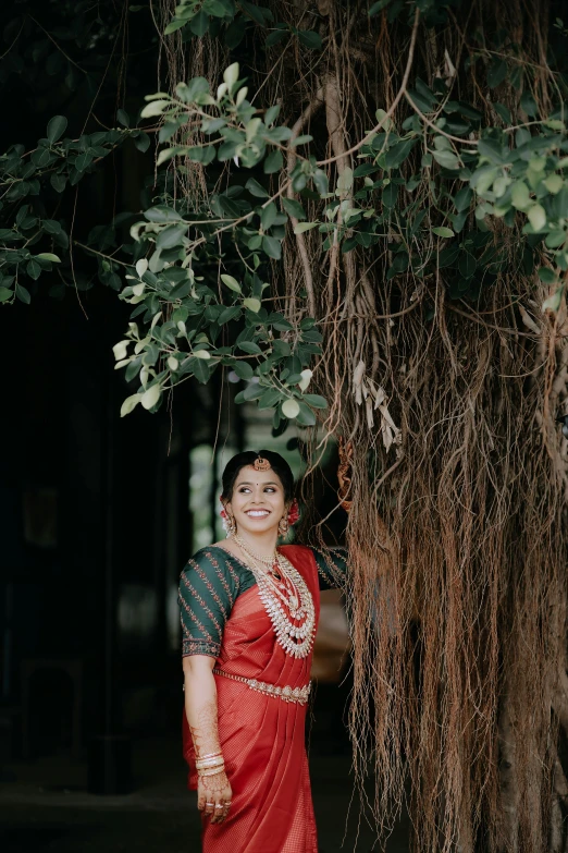 woman posing for the camera in front of a tree