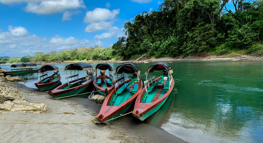 a row of small wooden boats sitting on the beach