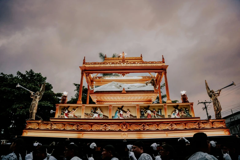 a fancy golden shrine at a festival in the rain