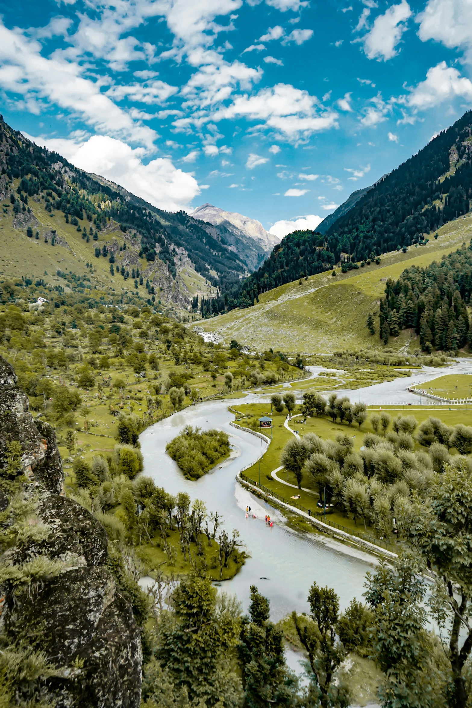 a mountain river surrounded by green hills and trees