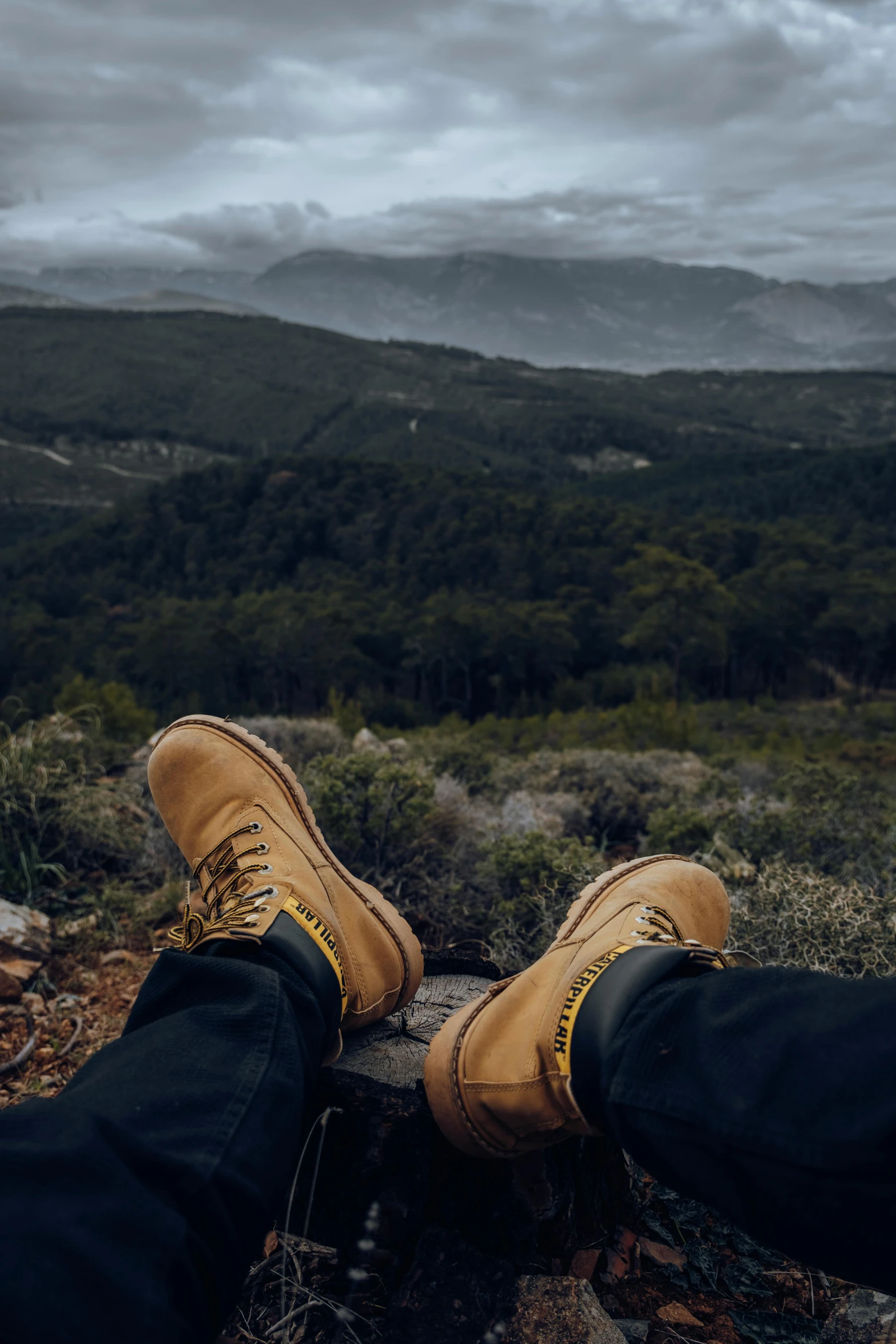 a person with their legs crossed over a rock on a hill