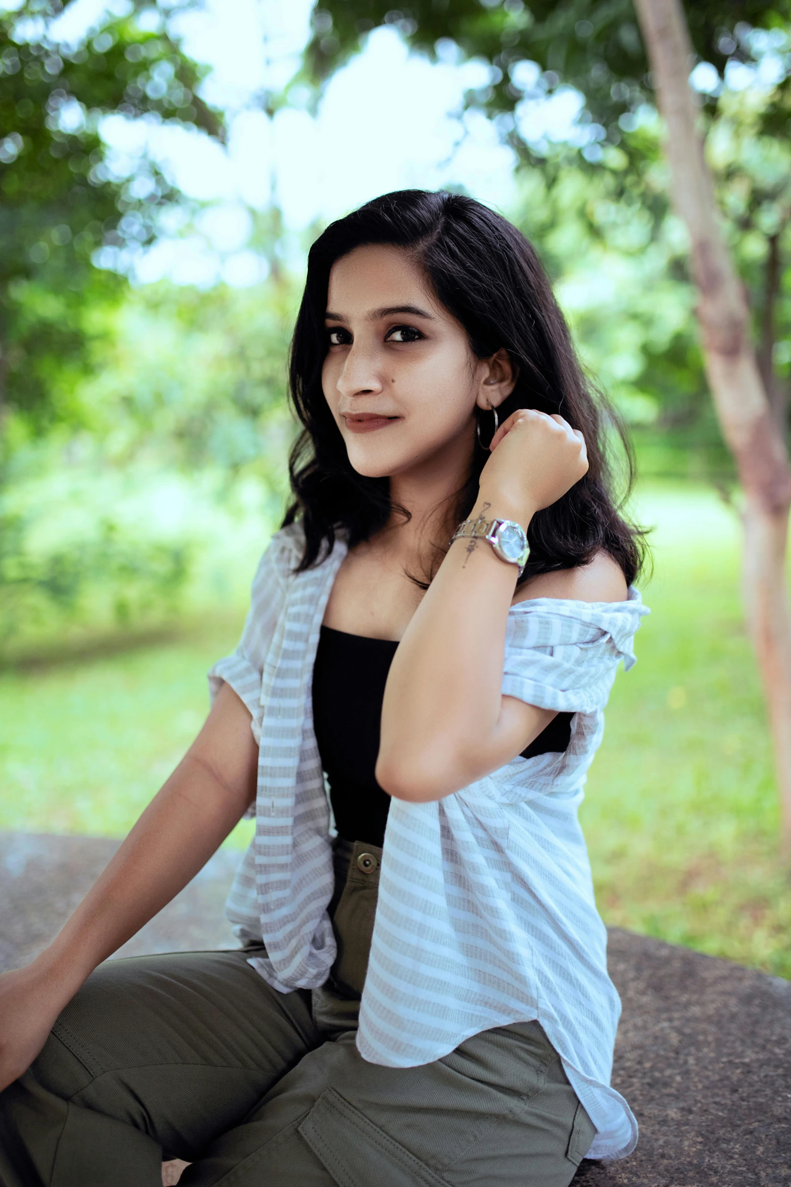 a woman sits in a park while looking at the camera