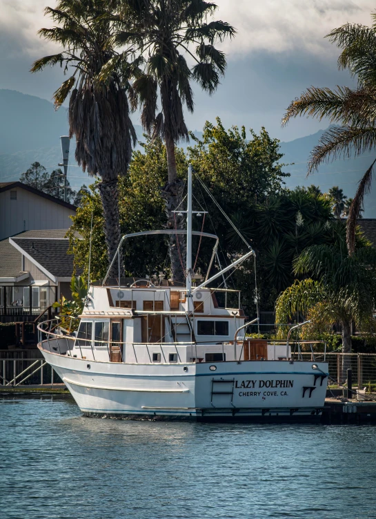 a white boat sitting in the water near a dock