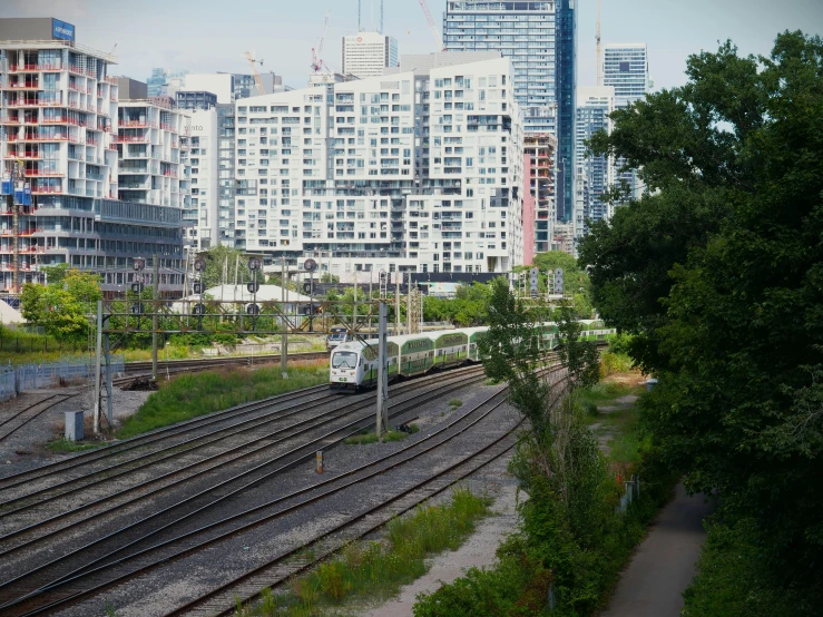 a view of buildings, train tracks and trees