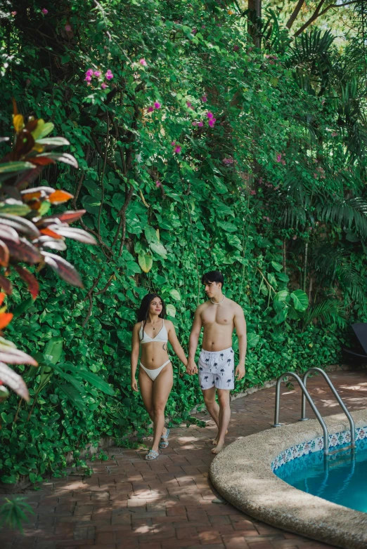 couple in white swimsuits walking away from the pool
