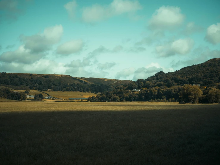 a large grassy area with two hills behind it