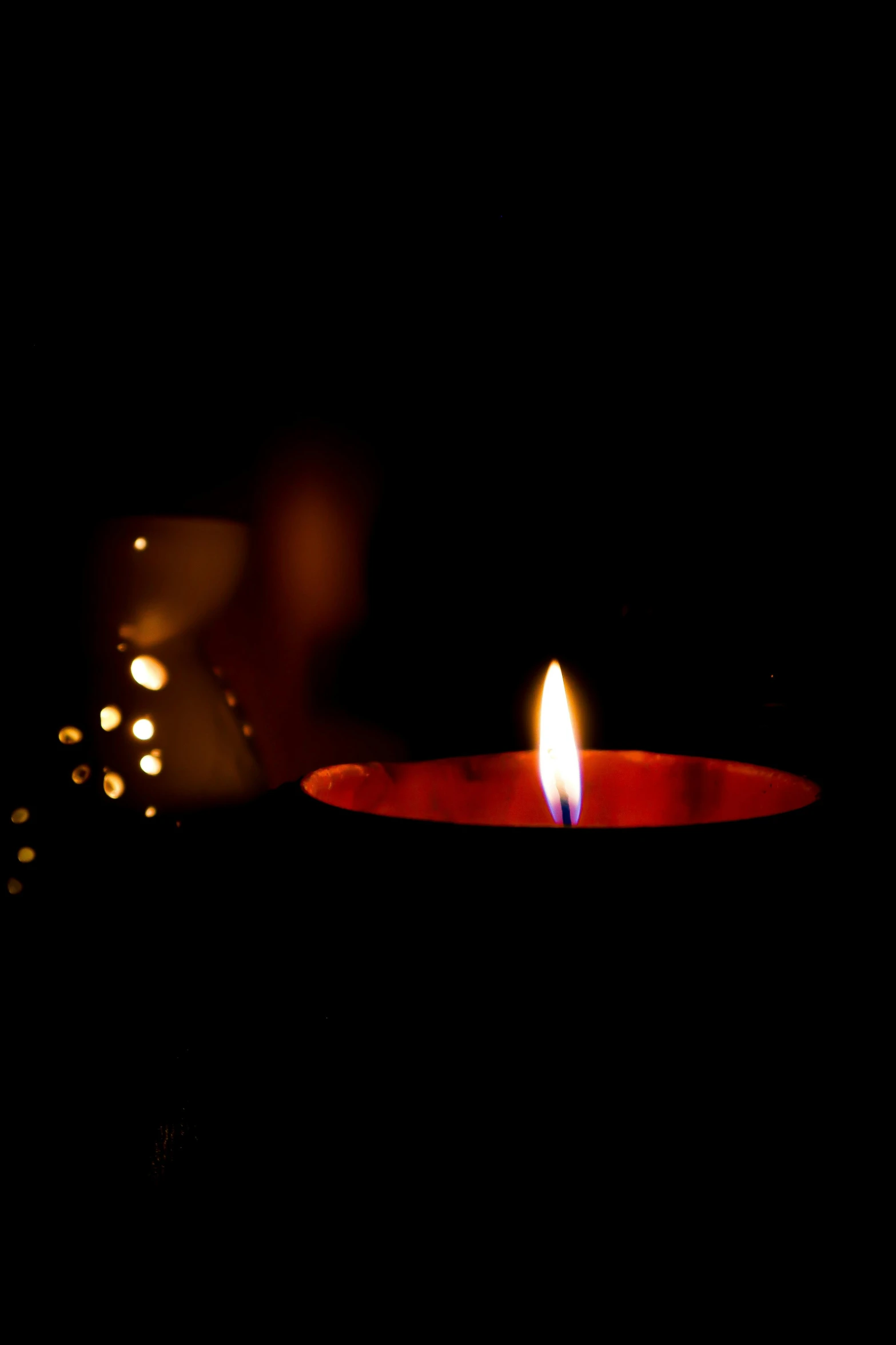 a candle is lit on a dark background