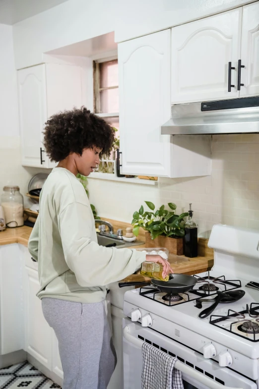 a woman standing in a kitchen next to an oven