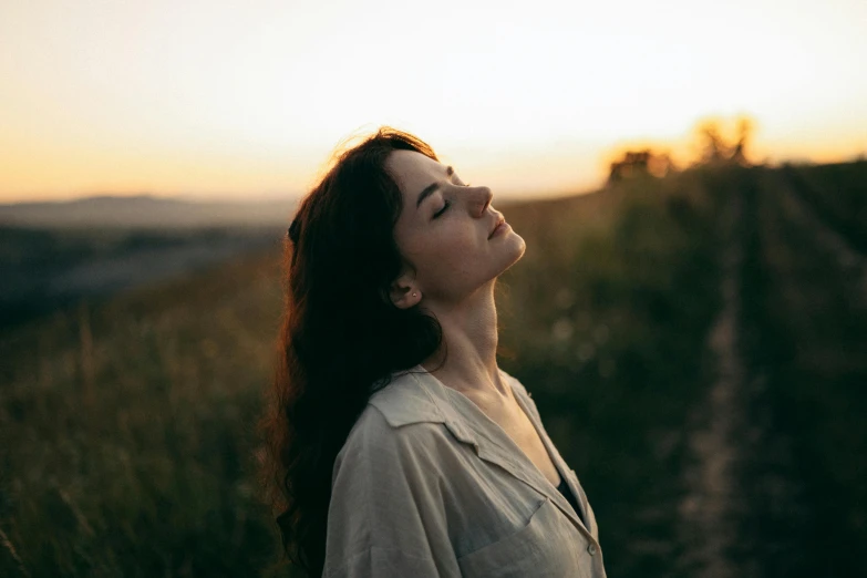 a woman with brown hair stares into the sky