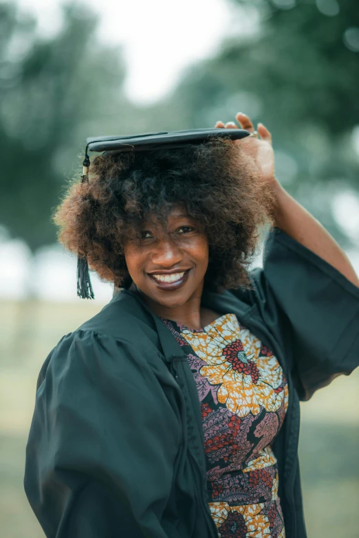 a black woman is smiling for the camera while wearing a graduation gown