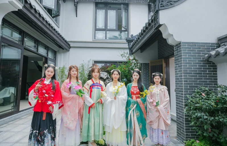 a group of asian women standing in front of a building