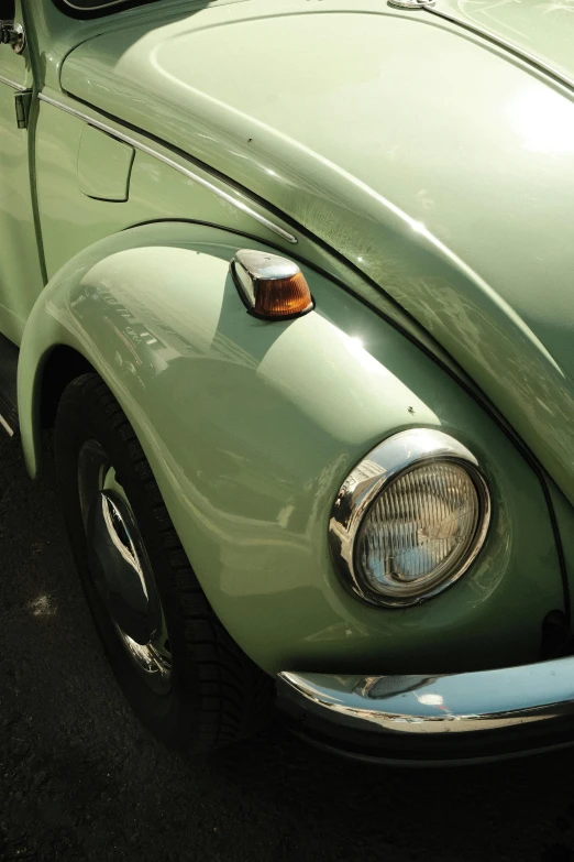 a green vw beetle parked in a lot