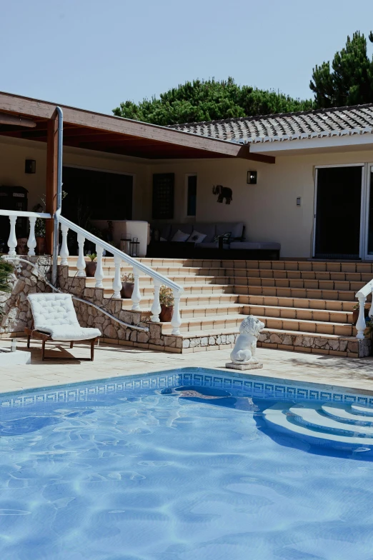 a pool with steps next to a stone building