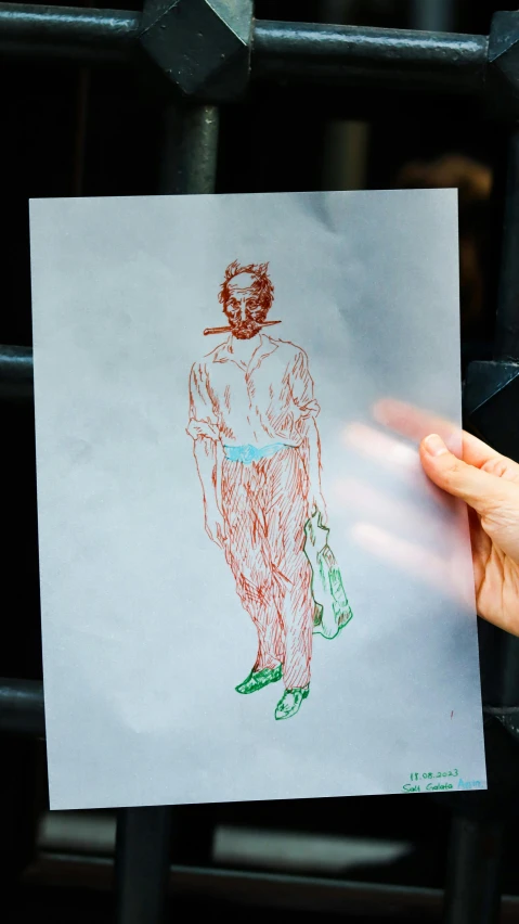 a hand holding a piece of paper with a drawing on it