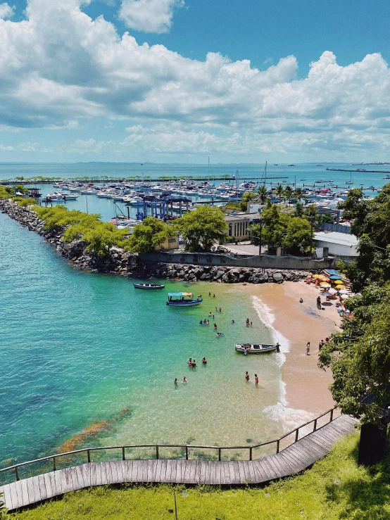 people are standing at the beach while others swim in the water